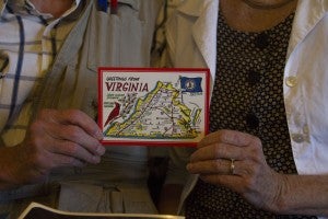 Photo by Carson Reeher Ron and Linda Card hold one of their postcards which depicts a map of Virginia which Ron Card drew. A closer look shows he included Keysville on the map, a fact he is proud of. 